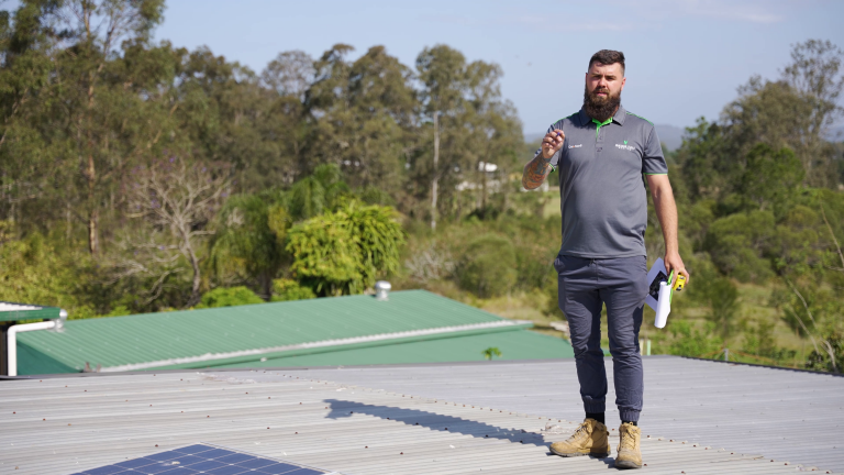 vantage point roofing team member standing on a metal roof