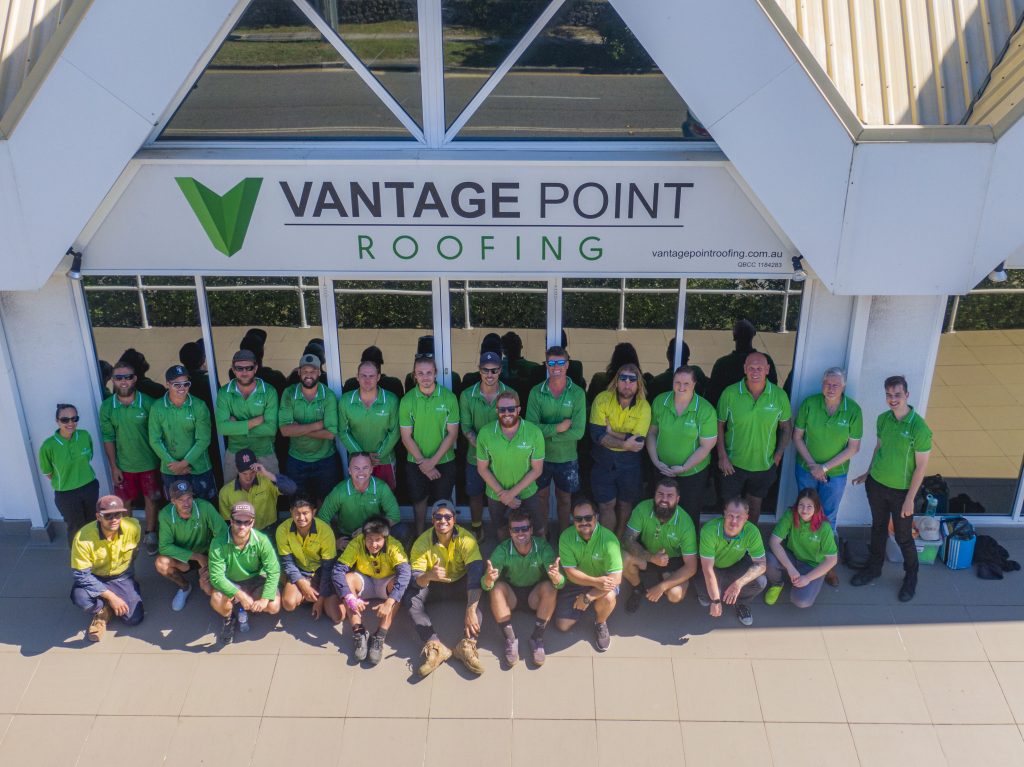 Vantage Point Roofing HQ with the team posing in front of the entrance.