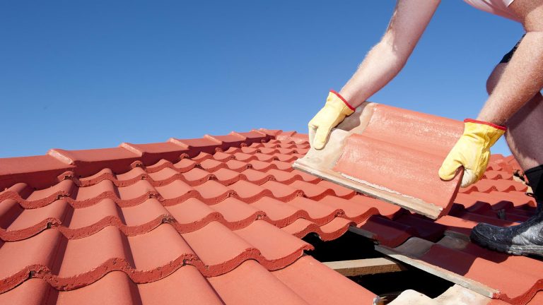 Roofer repairing roof tiles