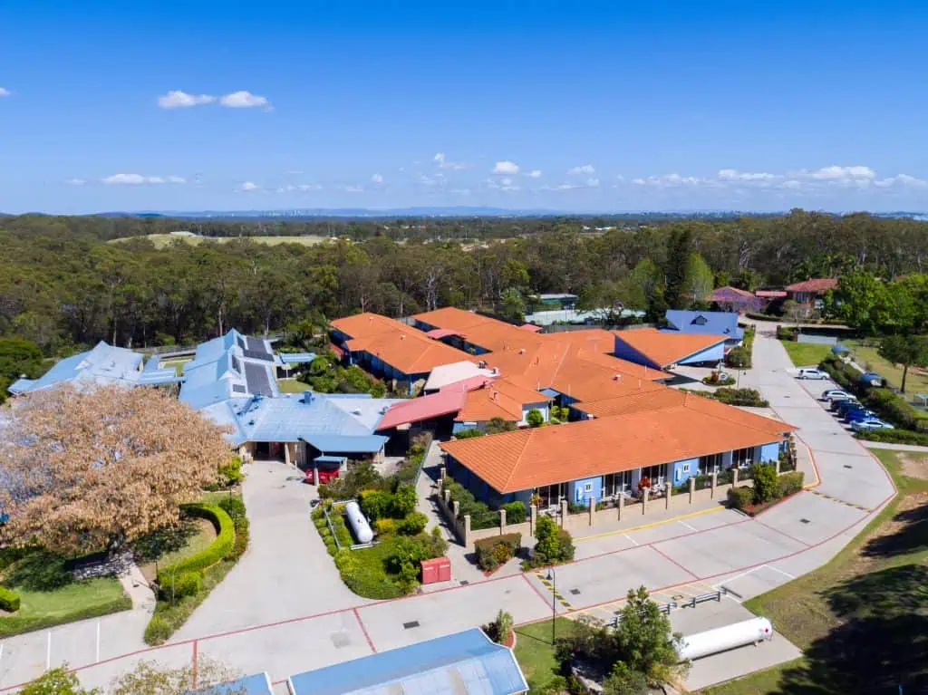 large commercial building aerial view with tile roof before roof replacement