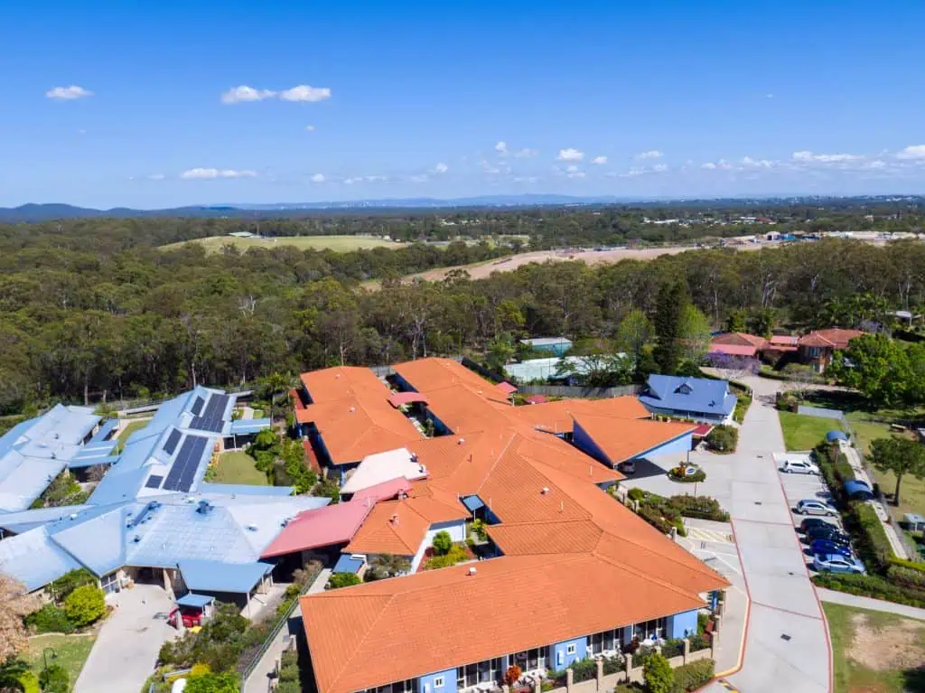 large commercial building aerial view with tile roof before roof replacement