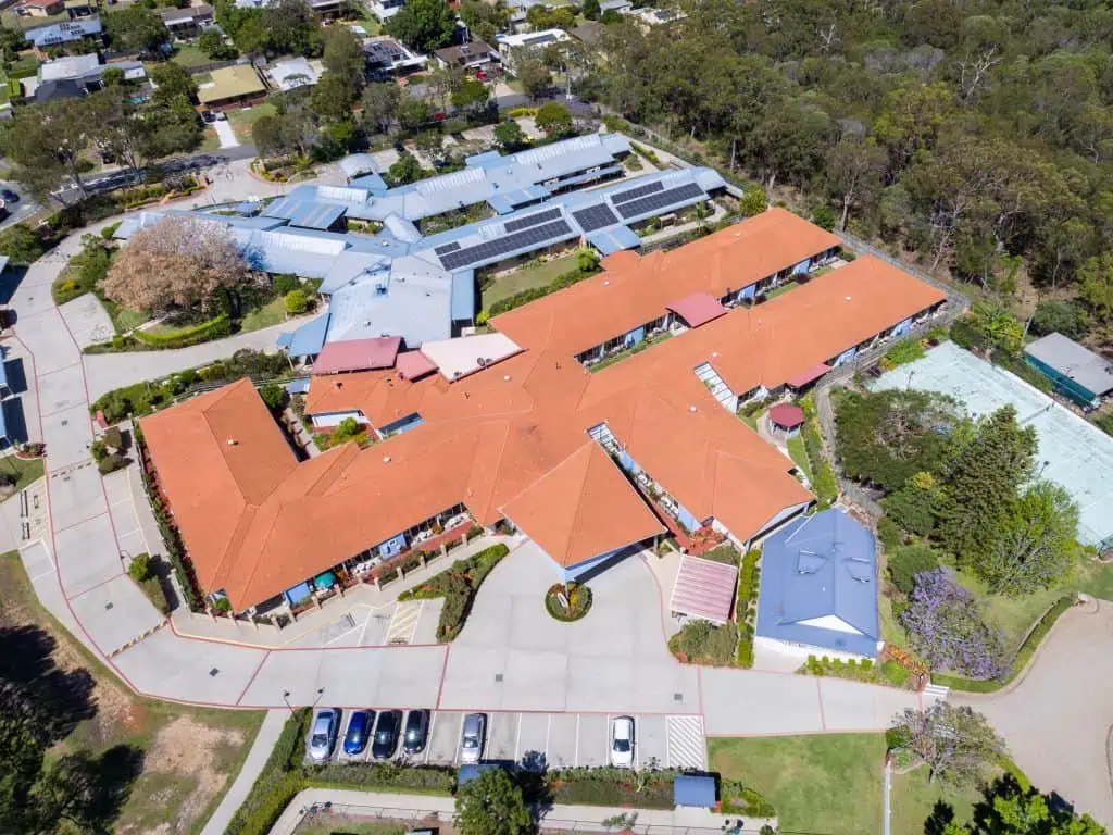 large commercial building aerial view with tile roof before roof replacement