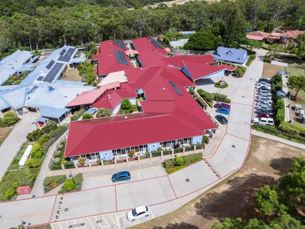 Red metal roof on a large commercial building with solar panels on the roof